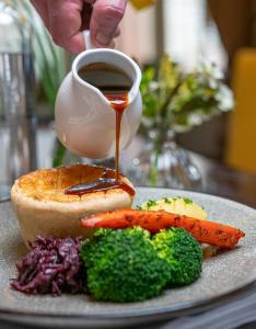 a plate of food with a cup of coffee and broccoli at Pontlands Park Hotel in Chelmsford +54 photos