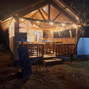 a house with a dining room with lights on it at Barrel cottages areguling in Kuta Lombok