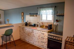 a kitchen with a counter with a sink and a stove at Noa's wooden cabin in Sha'al