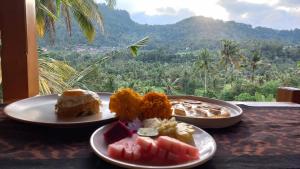 two plates of food on a table with a view at Lumbung Intan in Sidemen