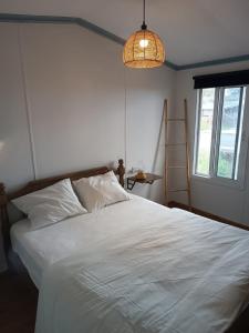 Sha'alにあるNoa's wooden cabinの白いベッドとランプのある寝室