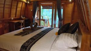 een slaapkamer met een groot bed met kussens erop bij Lumbung Intan in Sidemen