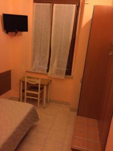 a room with a bed and a table and a window at Hotel Euro in Genoa