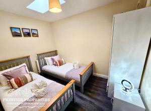 a small room with two beds and a shower at 12 Seacote Garden by Prestige Properties SA in St Bees
