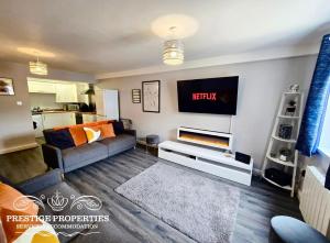 a living room with a couch and a tv at 12 Seacote Garden by Prestige Properties SA in St Bees