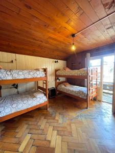 ein Zimmer mit drei Etagenbetten in einer Hütte in der Unterkunft Soley Hostel in Pucón