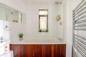 bagno bianco con vasca e finestra di Charming Summerhouse Annexe in lush gardens in Fowey a Fowey Altre 19 foto