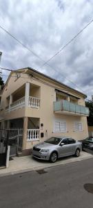 Un coche plateado aparcado delante de una casa. en Villa ANA, en Crikvenica