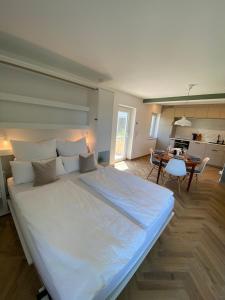 a large white bed in a room with a table at Seenland-Studio I 75 qm I Boxspringbett I Garten I Luxus-Bad in Spalt