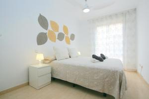 a white bedroom with a bed and a window at Apartamento Jazmín in Fuengirola