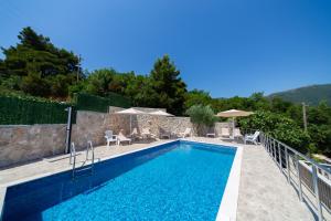 einen Pool mit Stühlen und Sonnenschirmen davor in der Unterkunft Golden View Apartments in Zelenika + 44 Fotos