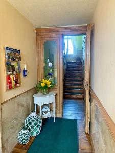 a hallway with a table with a vase of flowers at Pension "Am Stadtgraben" in Lübbenau