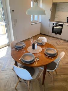 a dining room table with plates and glasses on it at Seenland-Studio I 75 qm I Boxspringbett I Garten I Luxus-Bad in Spalt +34 photos