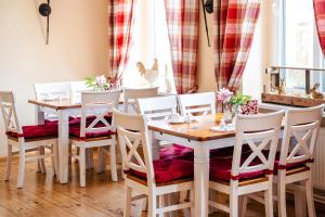 a dining room with white tables and white chairs at Pension "Am Stadtgraben" in Lübbenau