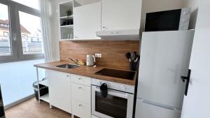 a kitchen with a white refrigerator and a sink at Böhl Station Appartments in Böhl-Iggelheim