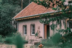 a small pink house with a red roof at Tajna Bazia in Nidzica