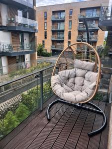 a chair sitting on top of a balcony at Luxury 2-Bedroom London Apartment, 25mins to Liverpool Street, Balcony, Free Parking in London