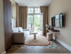 a living room with a couch and a tv at Hôtel des Arts in Angoulême