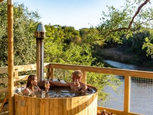 two children in a hot tub on a deck at AfriCamps at Bonamanzi Game Reserve in Hluhluwe