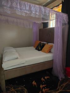a bed in a room with a canopy at Lulu house in Mombasa