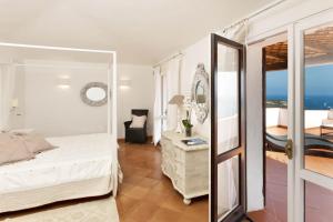 a bedroom with a bed and a mirror at Villa Azzurra con vista mozzafiato in Porto Cervo +21 photos