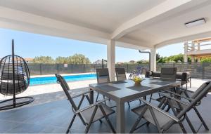 a table and chairs on a patio with a pool at Villa Emine in Banj
