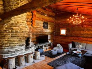 a living room with a stone fireplace in a log cabin at Ruka Aava in Ruka