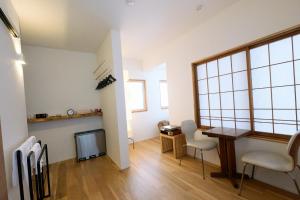 a living room with a television and a table and chairs at 蔕 Heta Nozawa Onsen in Nozawa Onsen