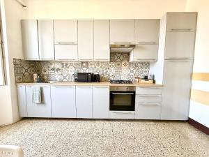 a white kitchen with white cabinets and appliances at Free Parking 5 minutes from the station in La Spezia +11 photos