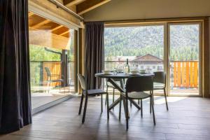 a dining room with a table and chairs and a large window at Lillaz Home - Apartments in Cogne