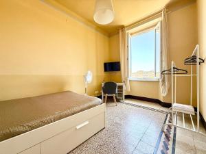 a bedroom with a bed and a window and a chair at Free Parking 5 minutes from the station in La Spezia