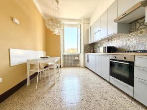 a kitchen with white cabinets and a table with chairs at Free Parking 5 minutes from the station in La Spezia
