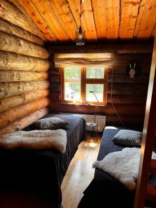 a room with two beds in a log cabin at Ruka Aava in Ruka