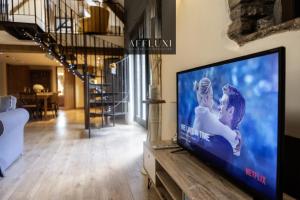un soggiorno con una grande TV a schermo piatto di Abergavenny Coach House Hot Tub Retreat a Monkswood
