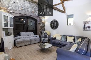 un soggiorno con 2 divani e un muro di pietra di Abergavenny Coach House Hot Tub Retreat a Monkswood