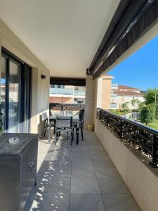 Un patio con una mesa y sillas en un balcón. en La Huperie, en Saint-Cyr-sur-Mer