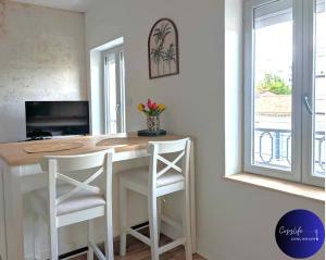 eine Küche mit einem Tisch und 2 weißen Stühlen in der Unterkunft L'Oasis by Cozylife - Centre Ville in Niort