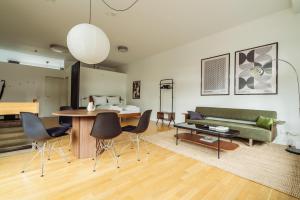 a living room with a couch and a table and chairs at MARAL Loft München Bogenhausen in Munich