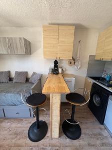 una piccola cucina con tavolo e due sgabelli di Appartement cosy à la montagne aux pieds des pistes pour 4 personnes et 1 bébé a Taninges