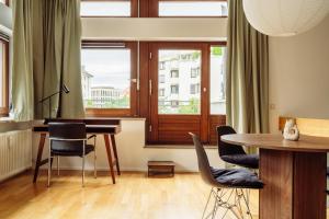 a living room with a table and chairs and a window at MARAL Loft München Bogenhausen in Munich