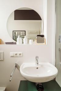 a bathroom with a sink and a mirror at MARAL Loft München Bogenhausen in Munich +18 photos