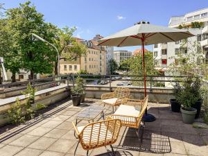 a patio with a table and chairs and an umbrella at MARAL Loft München Bogenhausen in Munich