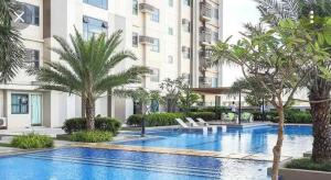 une piscine avec des palmiers devant un immeuble dans l'établissement Horizon 101, à Cebu
