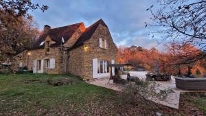 a stone house with a grill in the yard at Luxury Chateau w. pool & hot tub in Dordogne in Cazenac