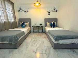 two beds sitting next to each other in a room at Spacious Comfort Stay in Seremban-5R3B 舒适温暖之家 in Seremban