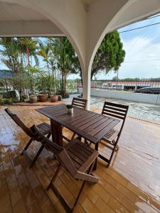 a wooden table and chairs on a patio at Spacious Comfort Stay in Seremban-5R3B 舒适温暖之家 in Seremban