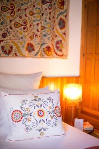 a bed with a pillow and a tapestry on the wall at Villa Thalassa Suites 3 Modern Comfort Traditional Greek Charm Private Courtyards Steps From Lindos Square & Beach in Líndos +8 photos