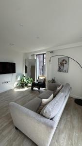 ein Wohnzimmer mit einer Couch und einem Sessel in der Unterkunft Salford Luxury 2Bed 2Bath Gym Balcony in Manchester