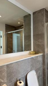 ein Badezimmer mit Toilette und großem Spiegel in der Unterkunft Salford Luxury 2Bed 2Bath Gym Balcony in Manchester