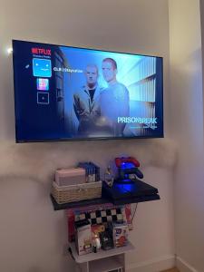 a flat screen tv hanging on a wall at 1BR GF - Beach pool, Netflix, PS4 , Wifi in Sampong